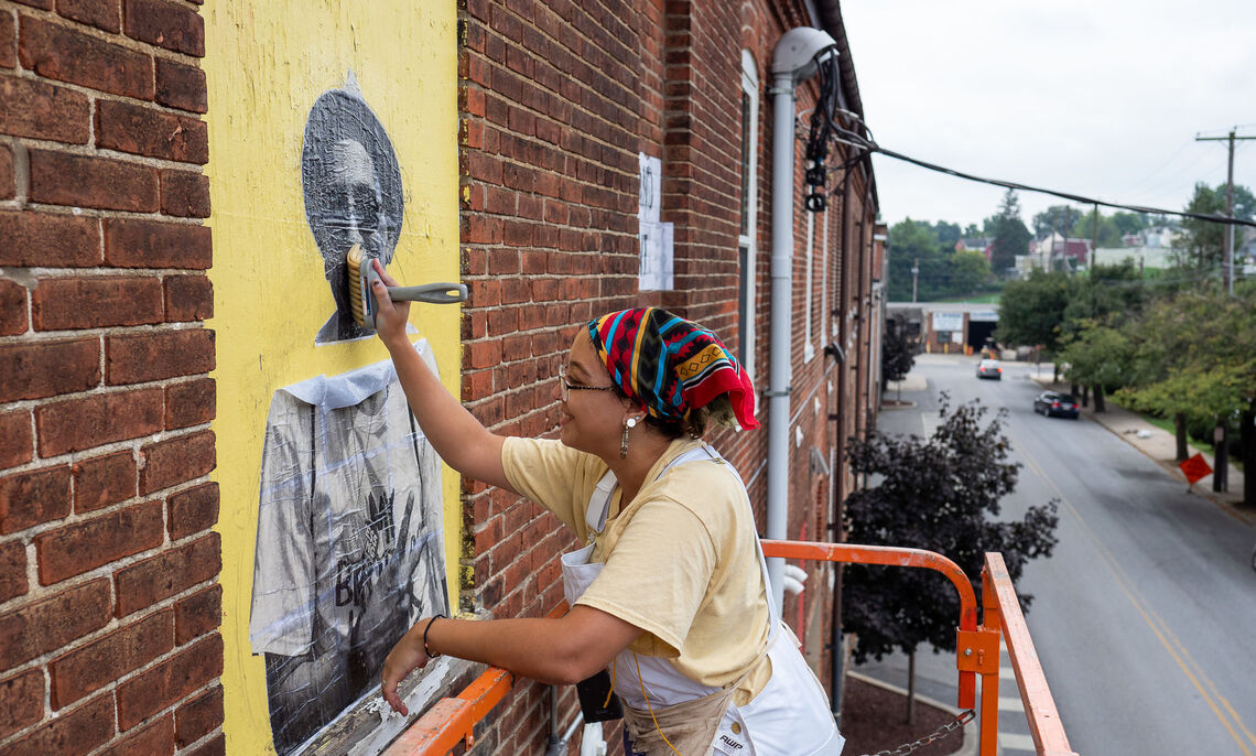 Salina Almanzar '13, photography technician at F&M, was hired to paint a mural in a Lancaster neighborhood.