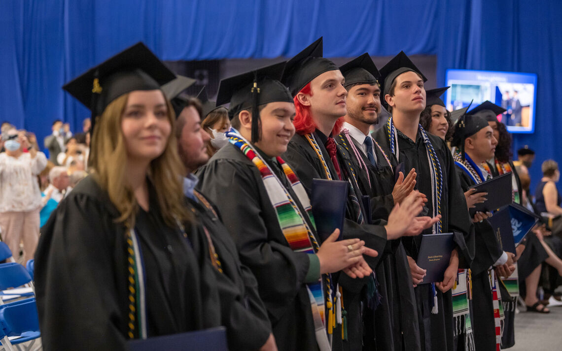 Happy seniors applaud their classmates during the degree-conferring portion of the program at Commencement 2022.