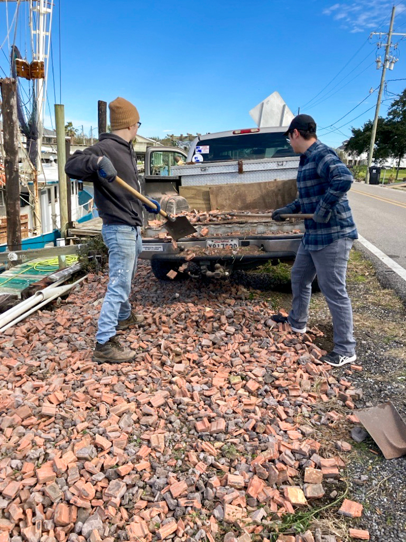 Daniel Cohen '25 and Soames Rummler '27 shovel crumbled bricks from a home's facade