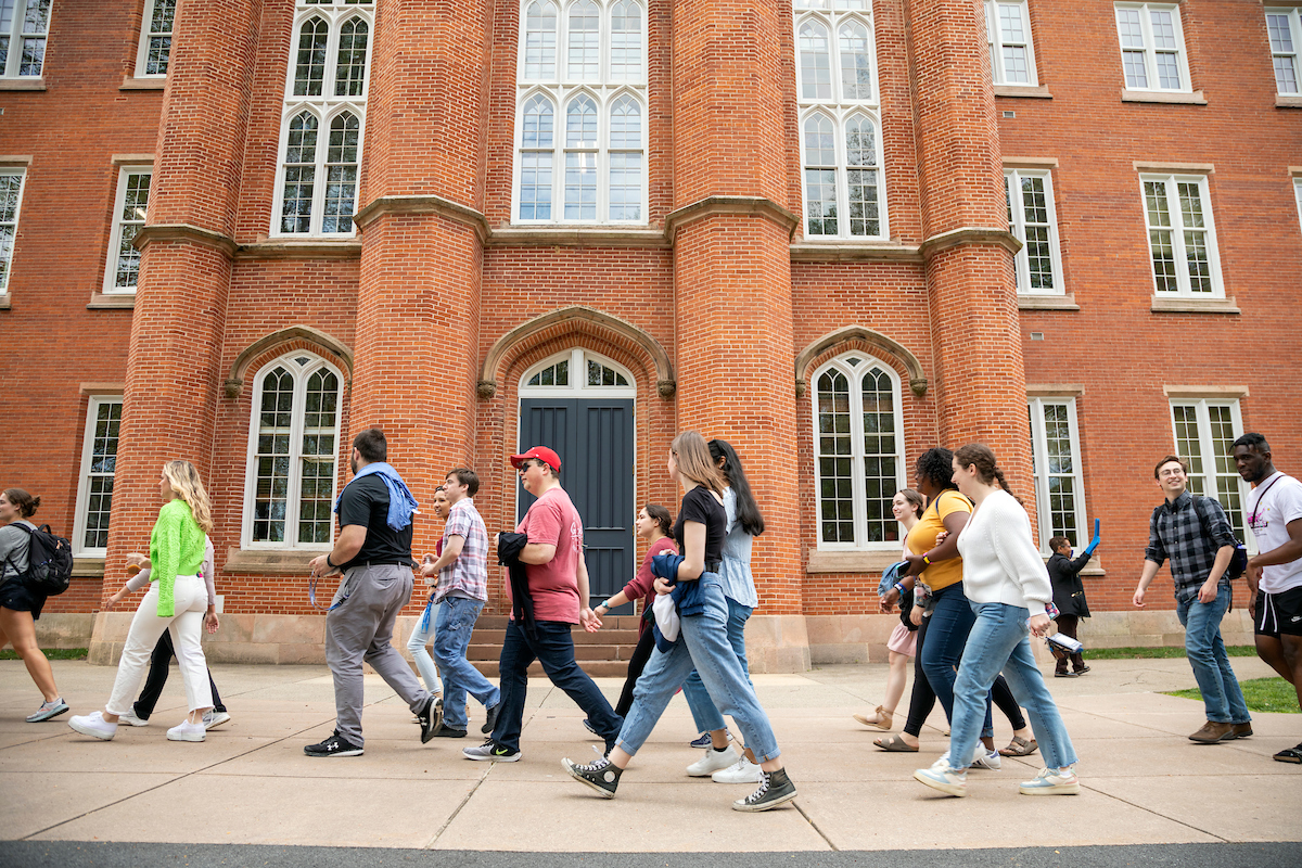 Students walk past Old Main as part of the Lux et Lex walk