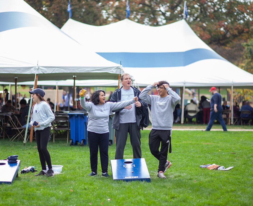 Family of three plays cornhole on Williamson Field.