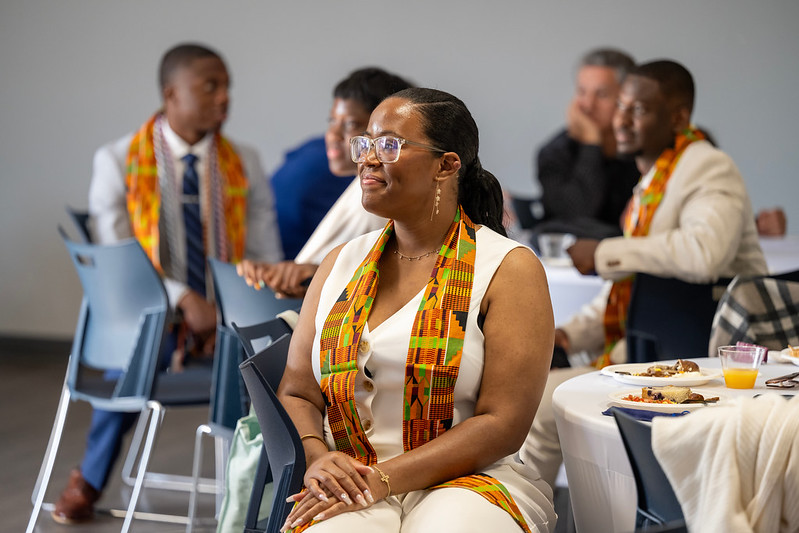 A photo of a 2025 senior seated at a table looking to the left during the African American Alumni Council Graduation Breakfast.