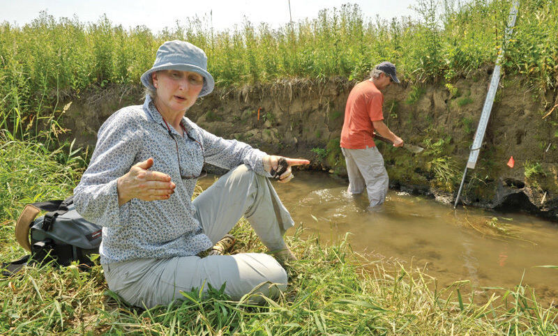 Dorothy Merritts discusses the landscape at Big Spring Run as Robert Walter 75 works in the stream.