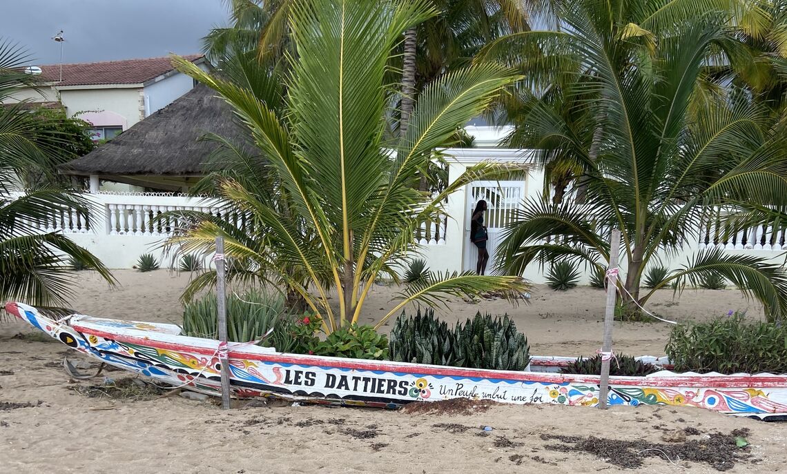 A home along the beach with a boat that shares Senegal's motto, 