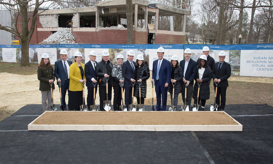 With demolition of Herman Arts Building underway in the background, donors, students, alumni, staff, faculty, architects and construction managers and College officials prepare to break the ground. From left to right: senior Emily Stein, Tom Murray, project manager, Robyn Piggott, chief of staff and secretary of the College, Chris McVoy and Steven Holl, architects,  Sue Washburn '73, Board chairman, Ben Winter '67 and Susan Winter, F&M President Daniel R. Porterfield, Colleen Weis '85, Provost Joel Martin, sophomore Sokhna Samb, Professor of Film and Media Studies Dirk Eitzen and Associate Professor of Art History and Department Chair of Art & Art History Kostis Kourelis.