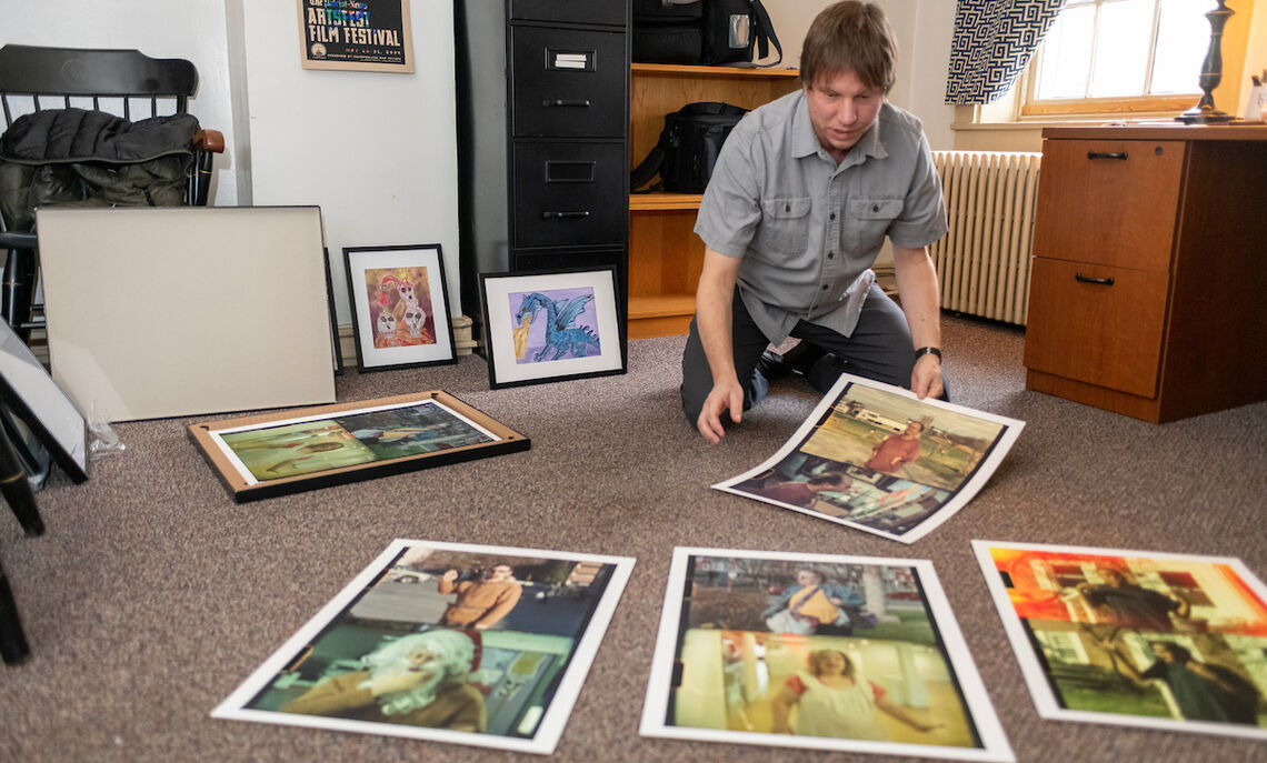 In his campus office, Hollenbaugh displays some of the works in the March 3-31 exhibit at the Susan and Benjamin Winter Visual Arts Center .