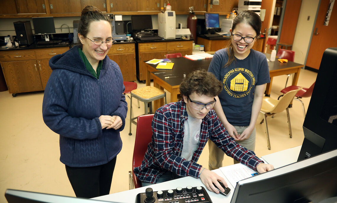 In this 2018 photo, Han Le and fellow chemistry major Angus Unruh  work with Professor Kate Plass on the latest computer microscope.