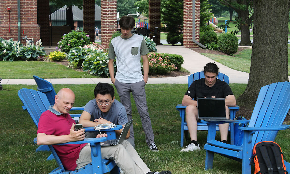 Senior physics major Yihao Zhang and Florence University Professor Luca Bossi use a phone app to communicate with the robot.