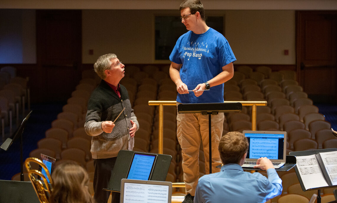 Brian Norcross works with students in his conducting class.